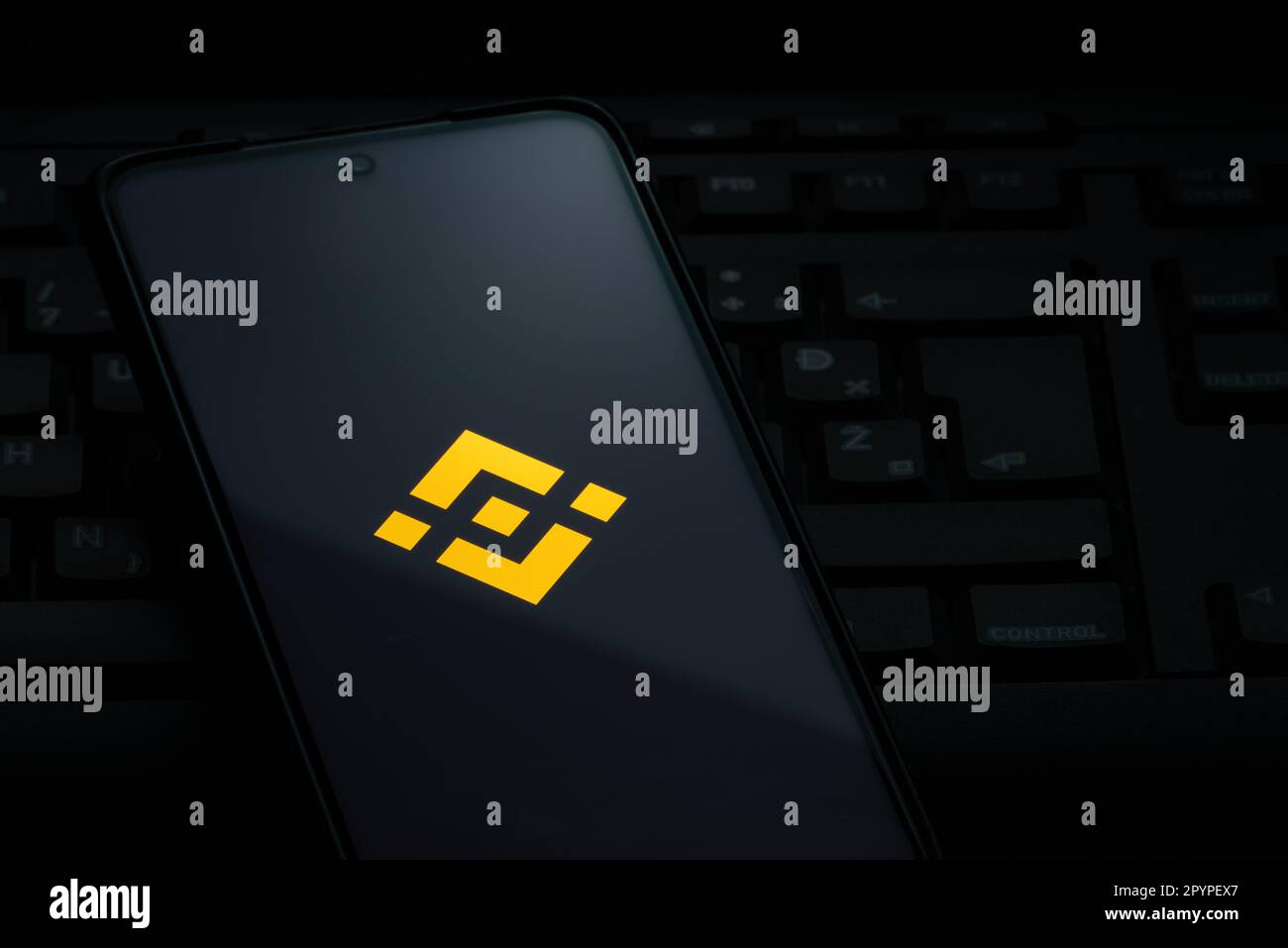 Ljubljana, Slovenia - 21 January 2023: Binance exchange logo on smartphone screen laying on computer keyboard Stock Photo