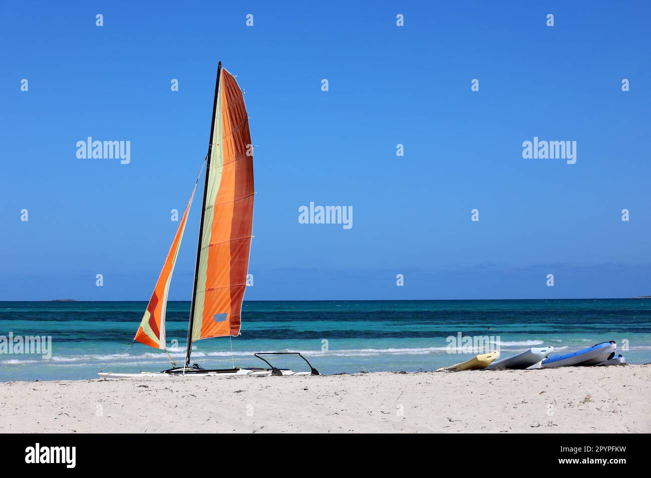 Catamaran sailboat on a sand on blue sea background. Water sports on ...