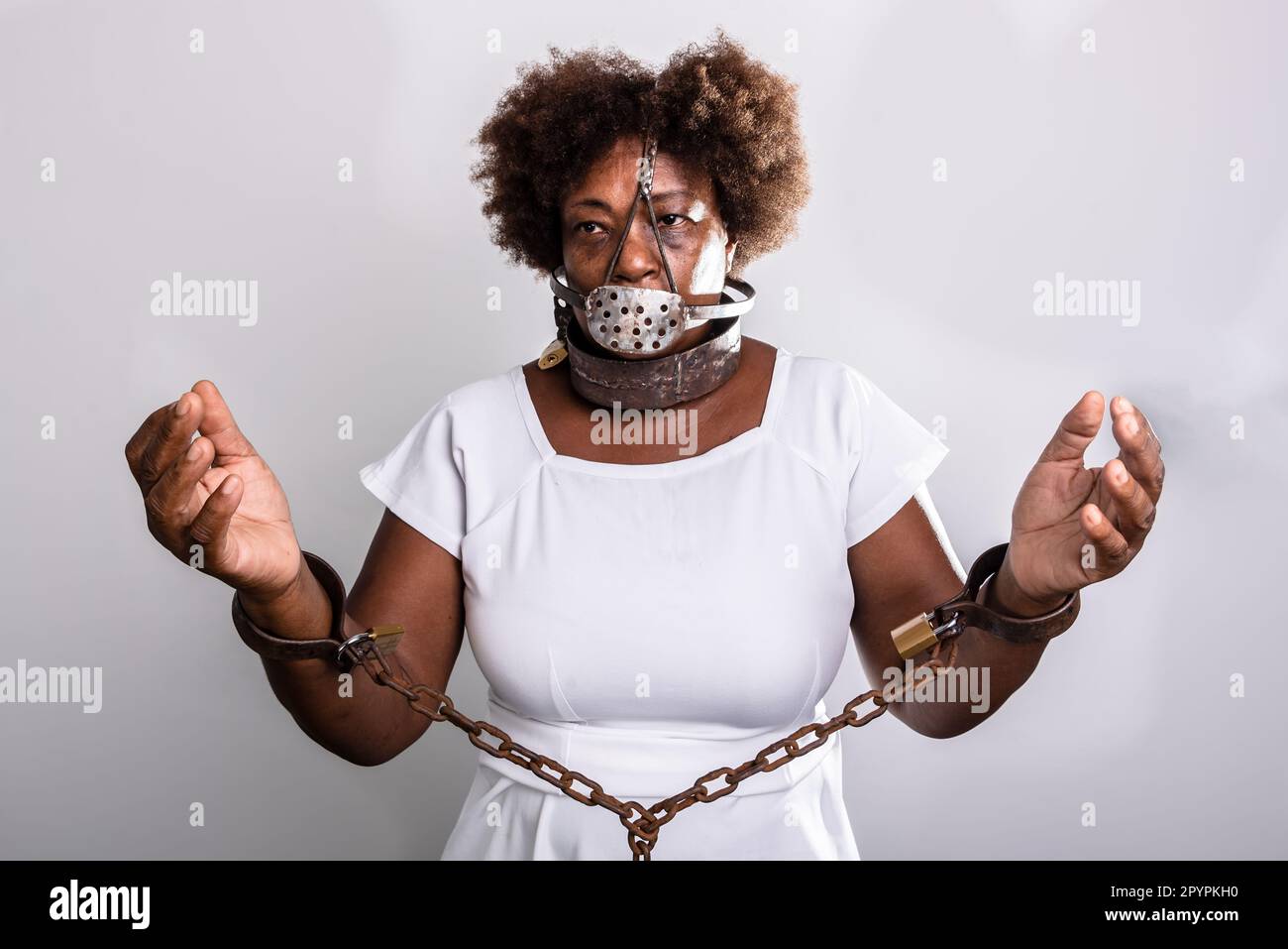 Portrait of a black woman in chains with an iron mask over her mouth.  Slavery in Brazil. Studio reproduction Stock Photo - Alamy