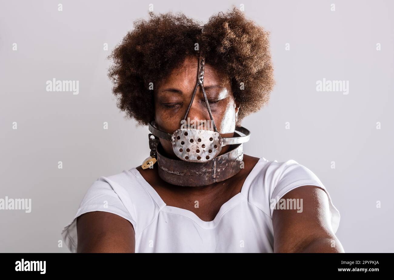 Portrait of a black woman in chains with an iron mask over her mouth.  Slavery in Brazil. Studio reproduction Stock Photo - Alamy