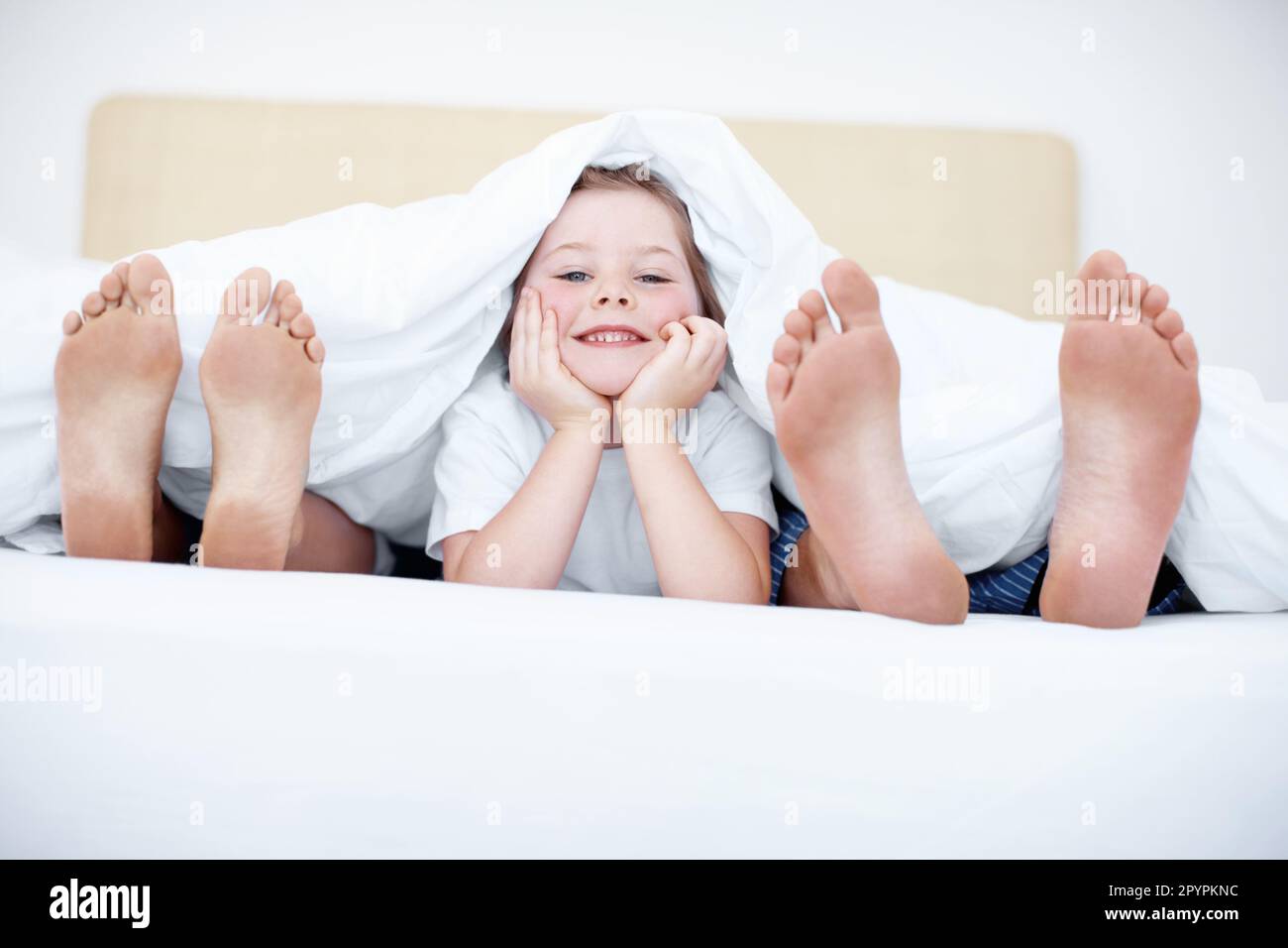 Footsie footsie. Fun shot of a child liying at the end of a bed between