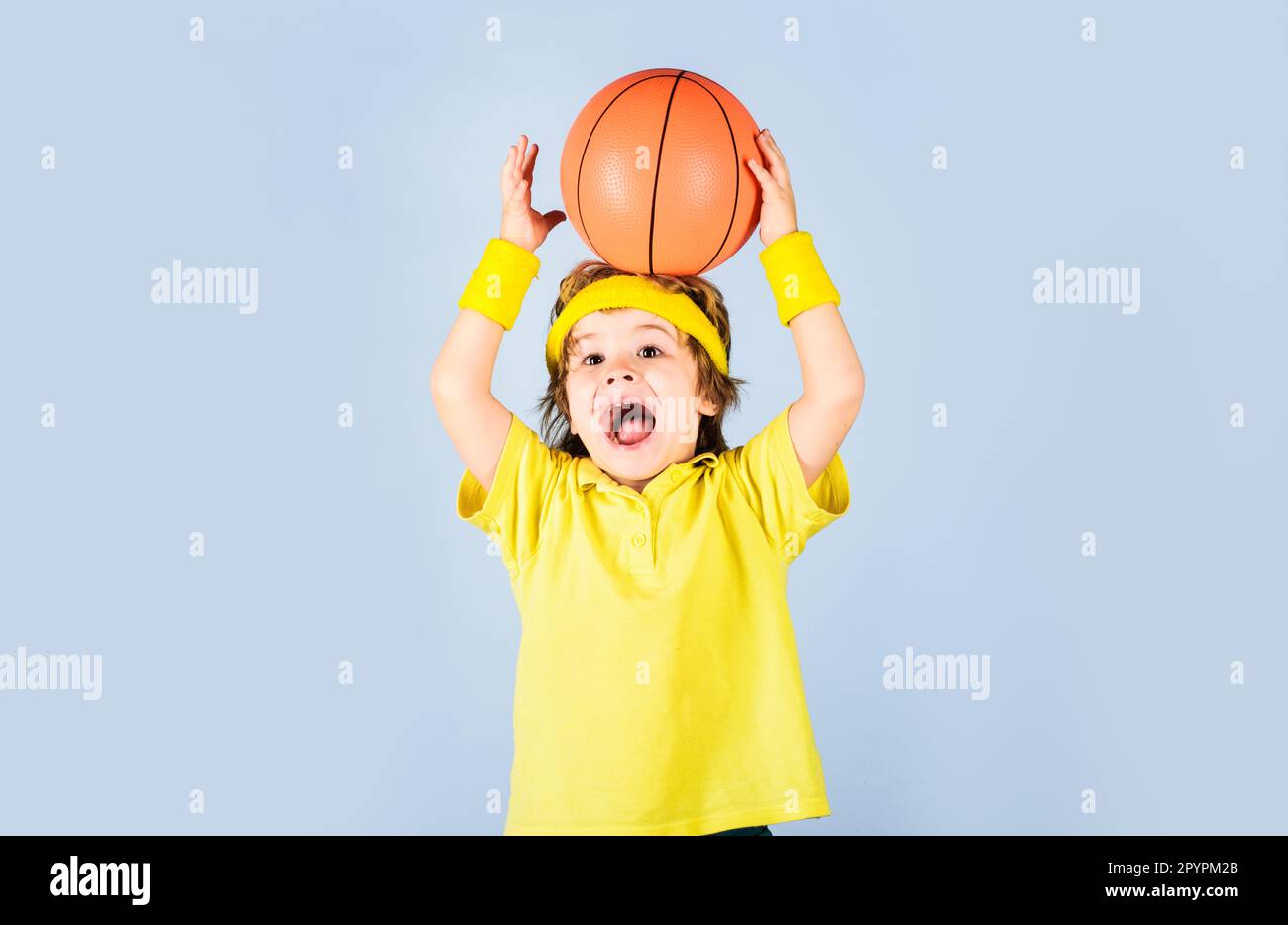 Little basketballer in sportswear throwing ball. Child boy in sport