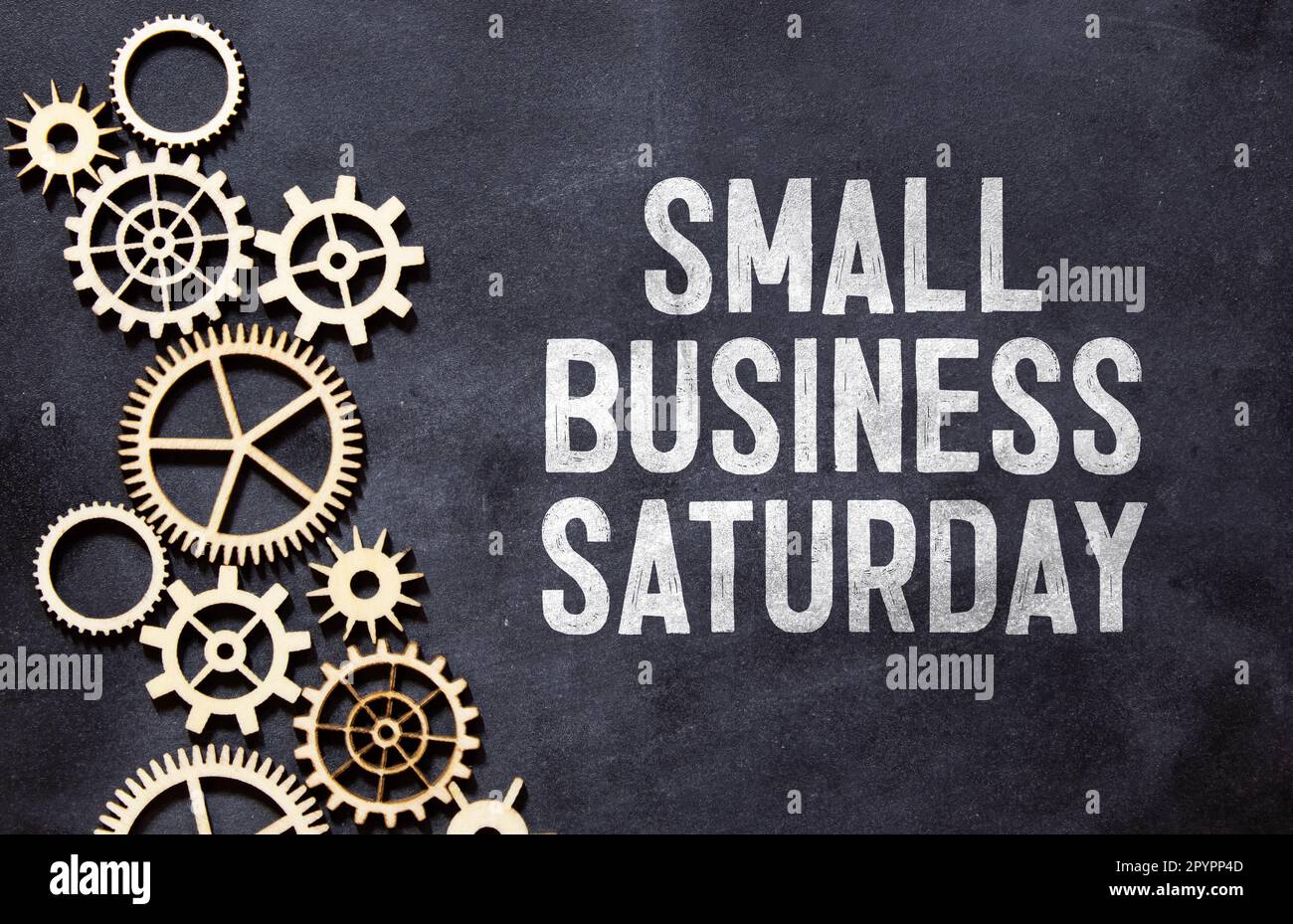 Small Business Saturday typography text on the blackboard set on wooden floor and brick background Stock Photo