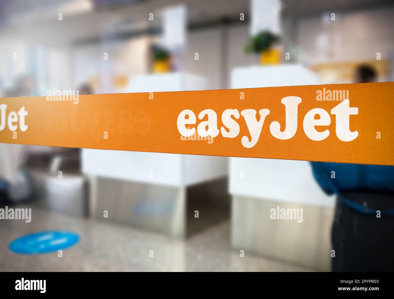 London, UK Jan 2023: Orange retractable belt barrier with the Easyjet logo inside an airport. Easyjet is a British multinational low-cost airline. Tra Stock Photo