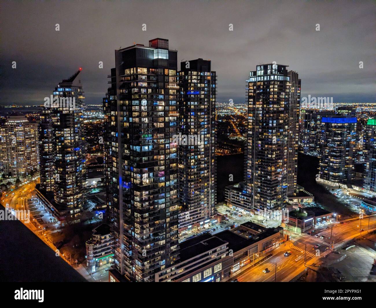 Aerial view of a vibrant city skyline at night, illuminated by bright ...
