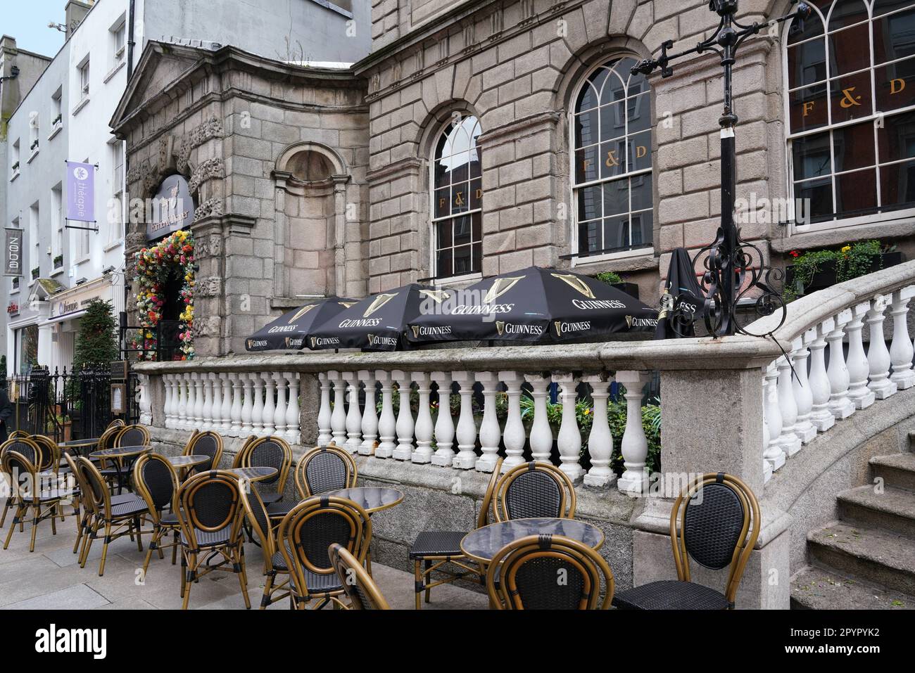 Chairs and tables set up on the sidewalk in front of Powerscourt