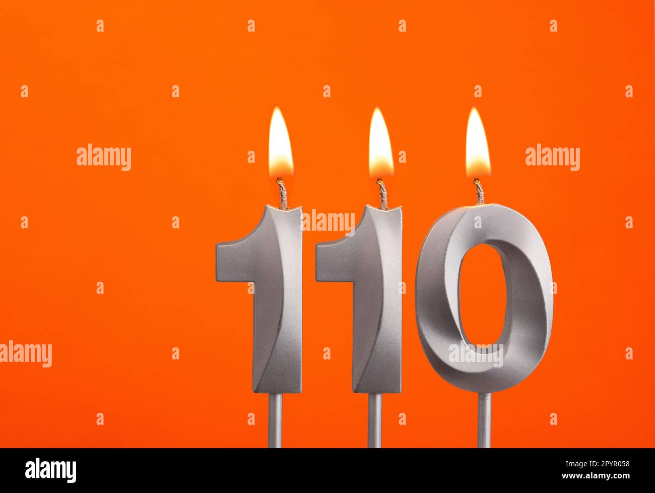 Candle number 110 - Birthday in orange background Stock Photo - Alamy