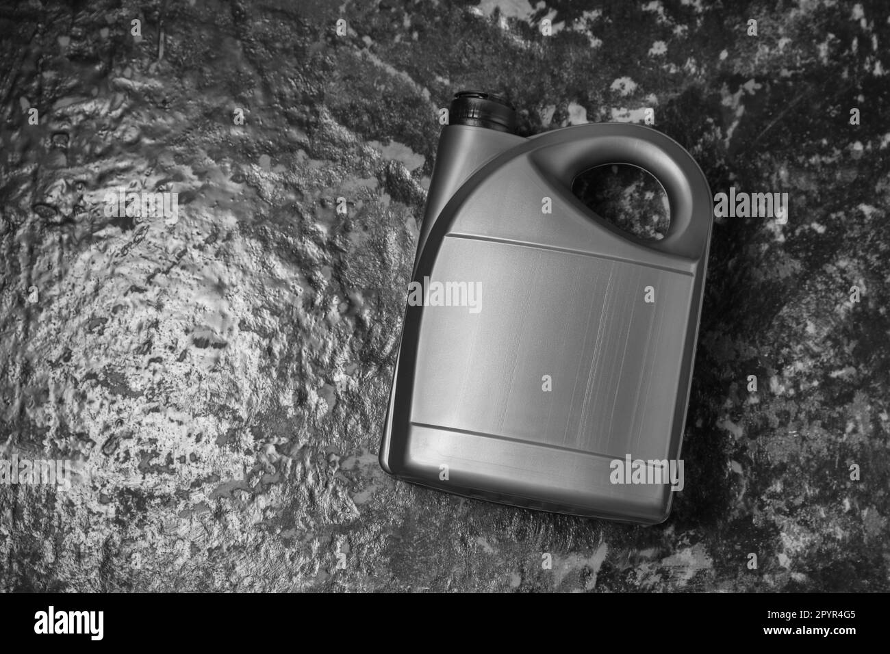 Motor oil in grey canister on black table, top view. Space for text