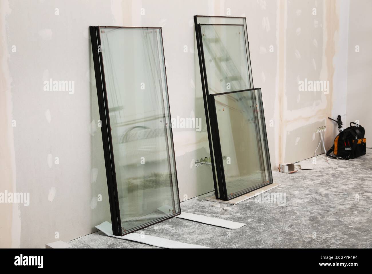 Double glazing windows on floor near plasterboard wall indoors Stock Photo