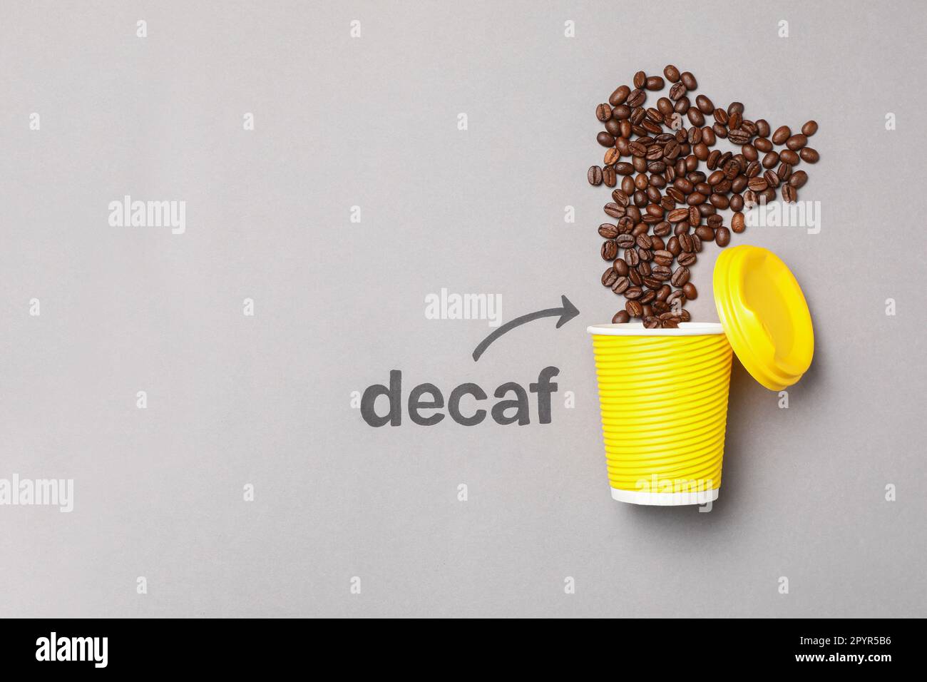 Word Decaf and arrow pointing at takeaway paper cup with coffee beans ...