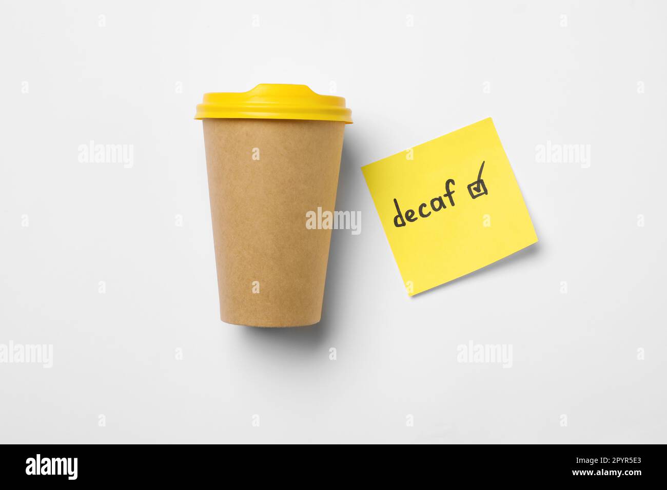 Takeaway coffe cup, note with word Decaf and checkbox on white background, flat lay Stock Photo