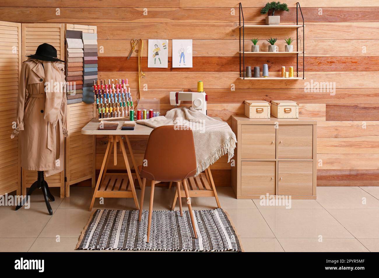 Interior of stylish atelier with tailor's workplace, mannequin and