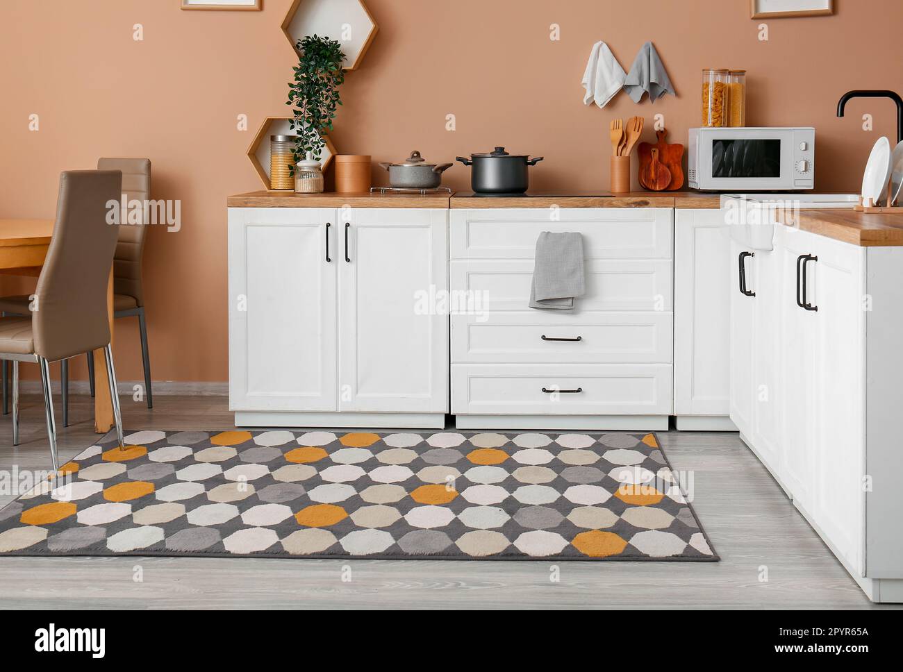 Interior of modern kitchen with white counters and stylish rug Stock ...