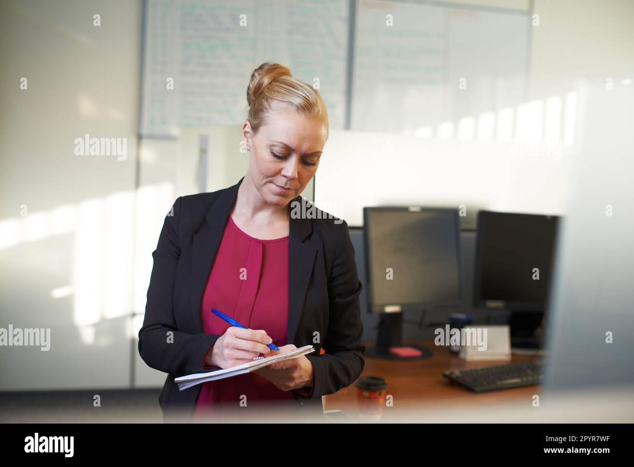 Making a few notes on the office. an attractive businesswoman making ...