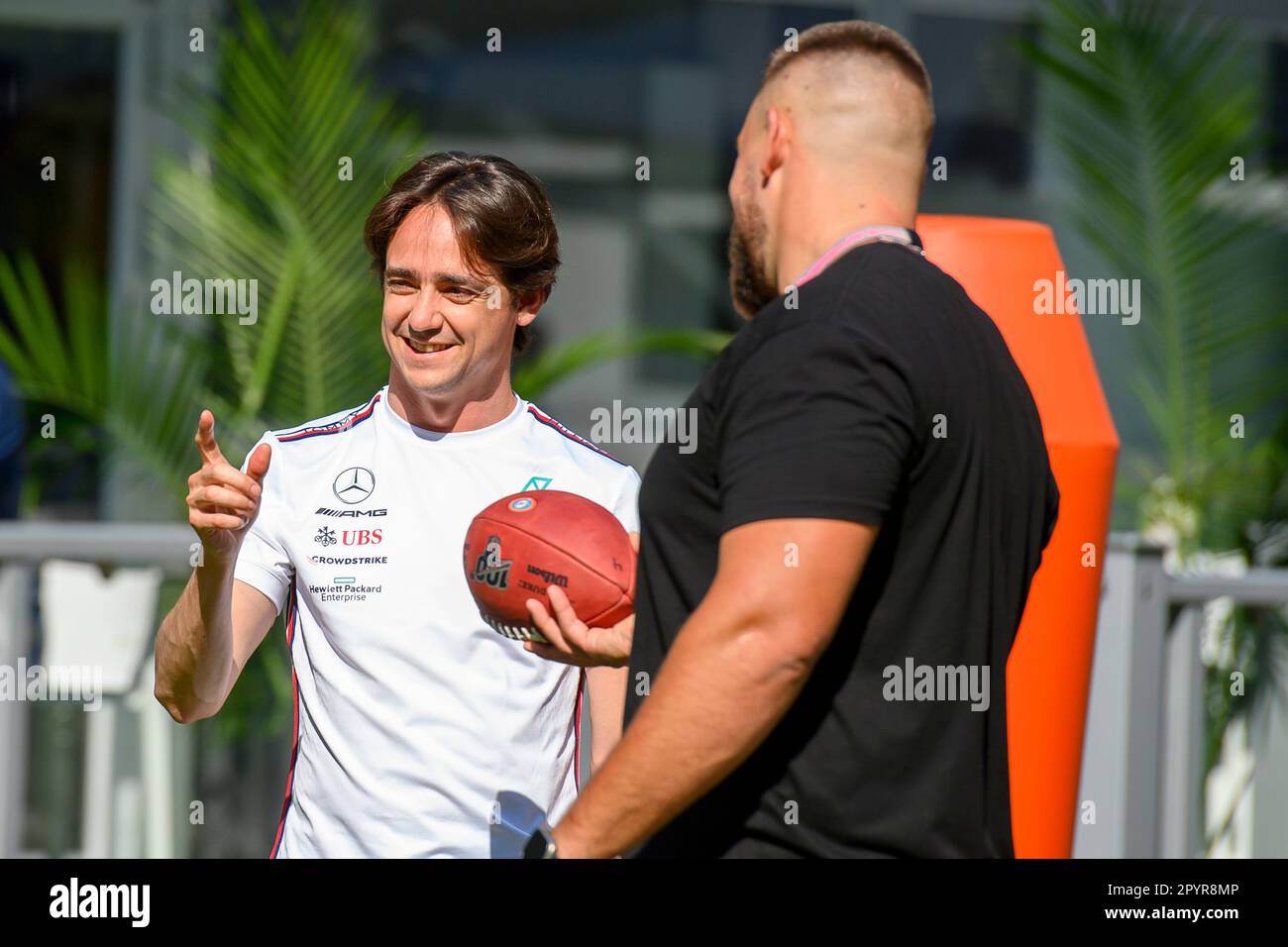 4th May 2023: Miami International Autodrome, Miami Gardens, Florida, USA: Formula 1 Crypto.com Miami Grand Prix 2023: Arrival and Inspection Day: MoneyGram Haas reserve driver Esteban Gutierrez runs a football drill as  instructed by NFL Miami Dolphin defensive tackle Zach Sieler at the Team Village. Stock Photo