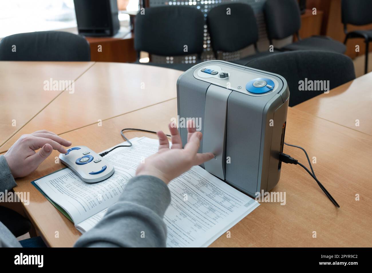 A visually impaired man uses a scanning and reading machine Stock Photo