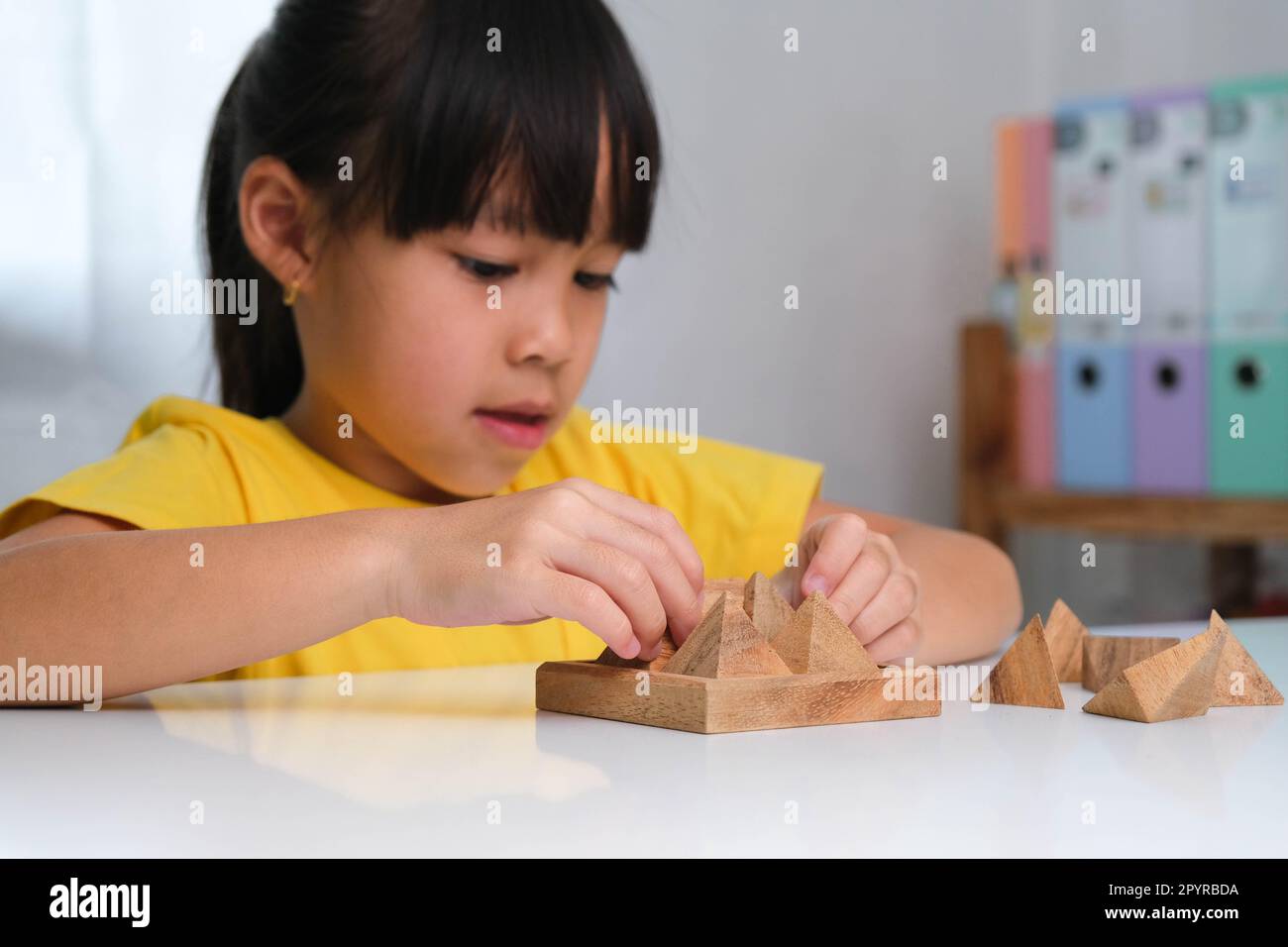 asian-cute-little-girl-playing-with-wooden-toy-jigsaw-puzzle-pyramid-on