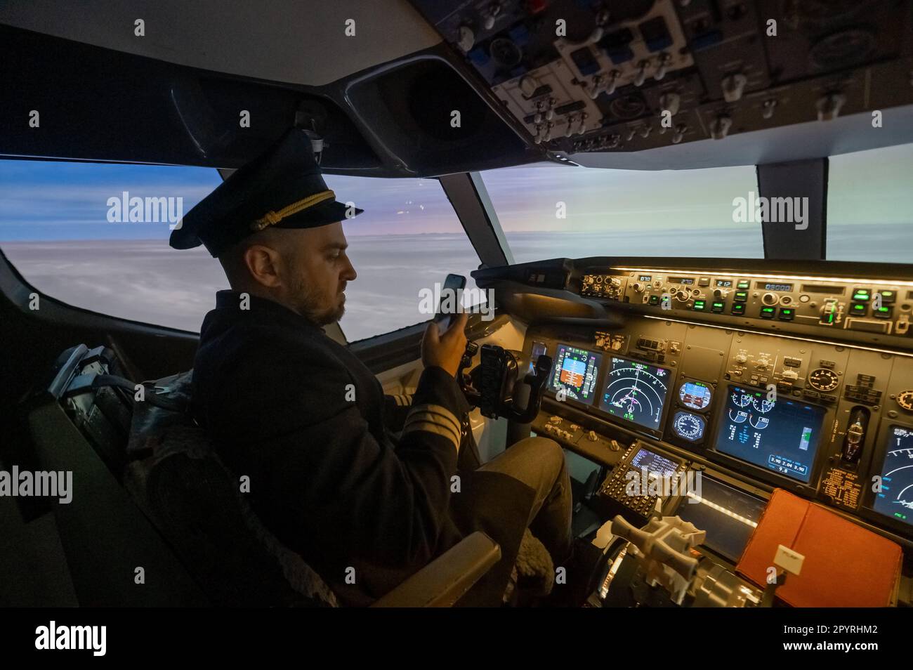 The pilot uses a smartphone while flying the plane. Autopilot Stock