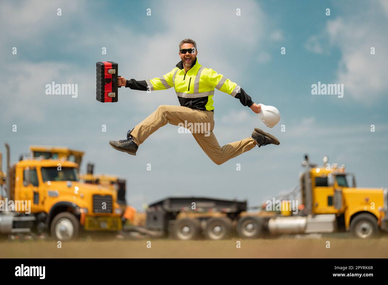 Construction builder excited jump in building uniform on buildings ...