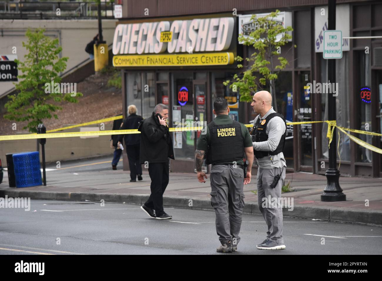 Linden, US, 04/05/2023, Police officers converse with each other at the crime scene. Bullet