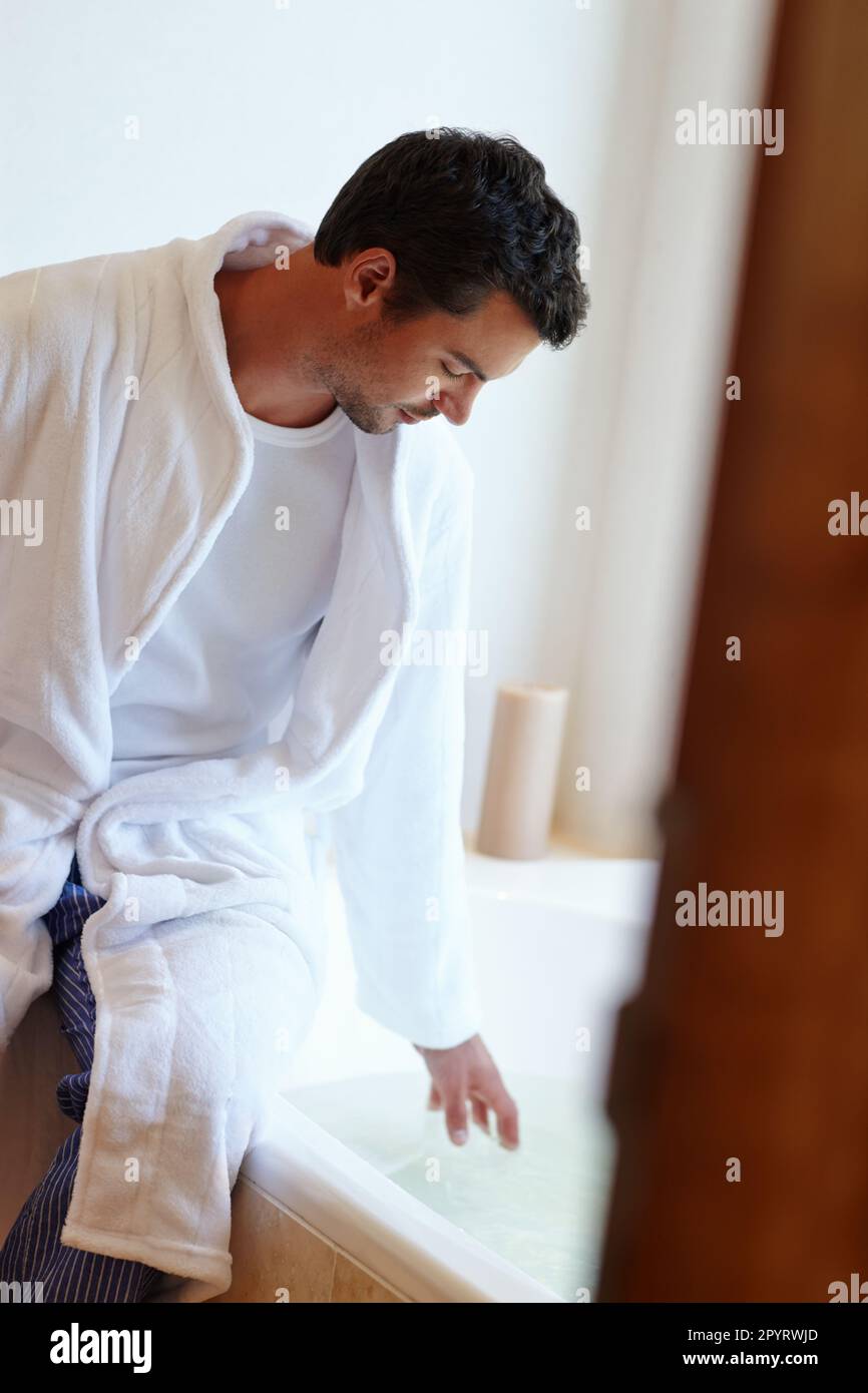 Running the perfect bath is an art. A handsome man running himself a