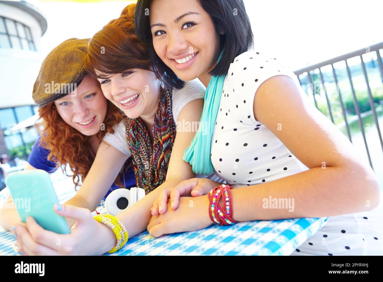 Were the online generation. A group of adolescent girls laughing as they look at something on a smartphone screen. Stock Photo