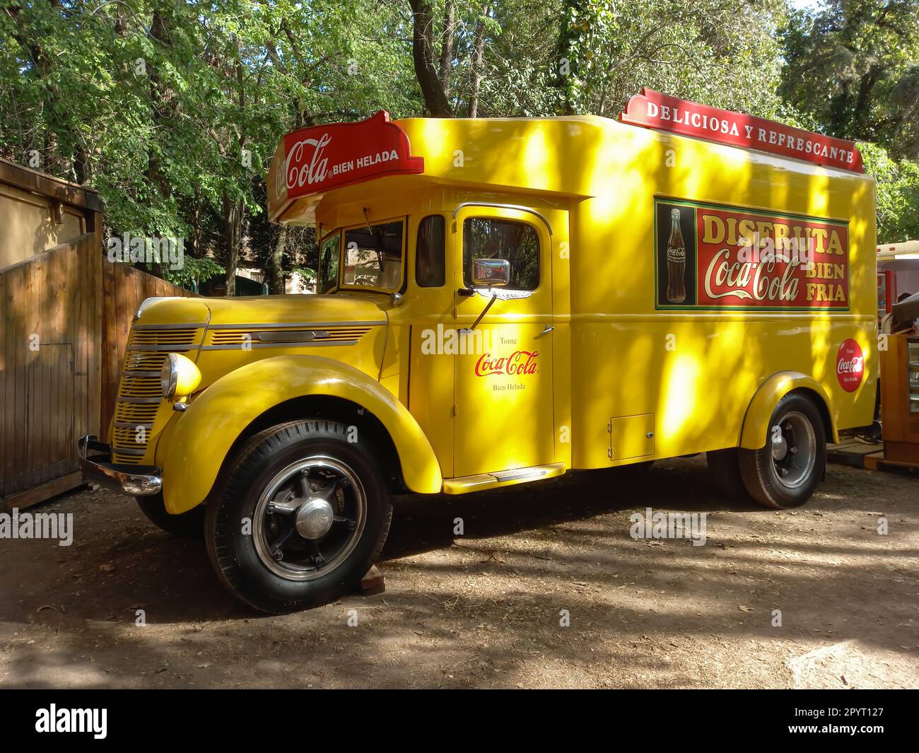 A vintage yellow 1930s International Harvester Coca-Cola delivery truck in a park. Stock Photo