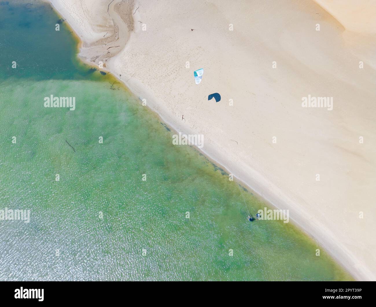 Aerial view of a kite surfer over a sand bar in a coastal inlet at