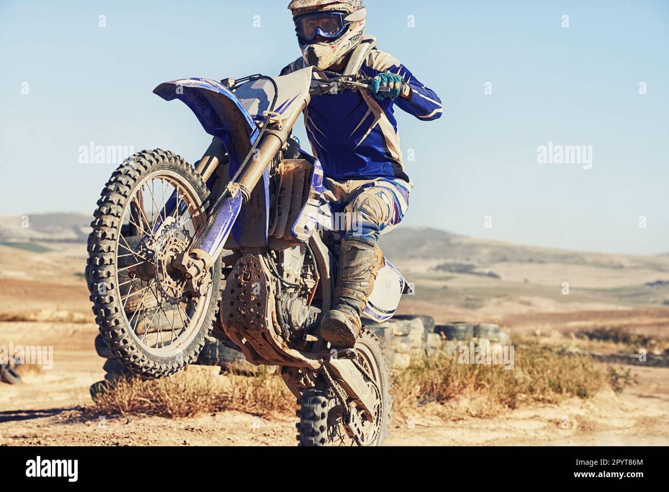 Hes in full control. a motocross driver performing a wheelie during a race. Stock Photo