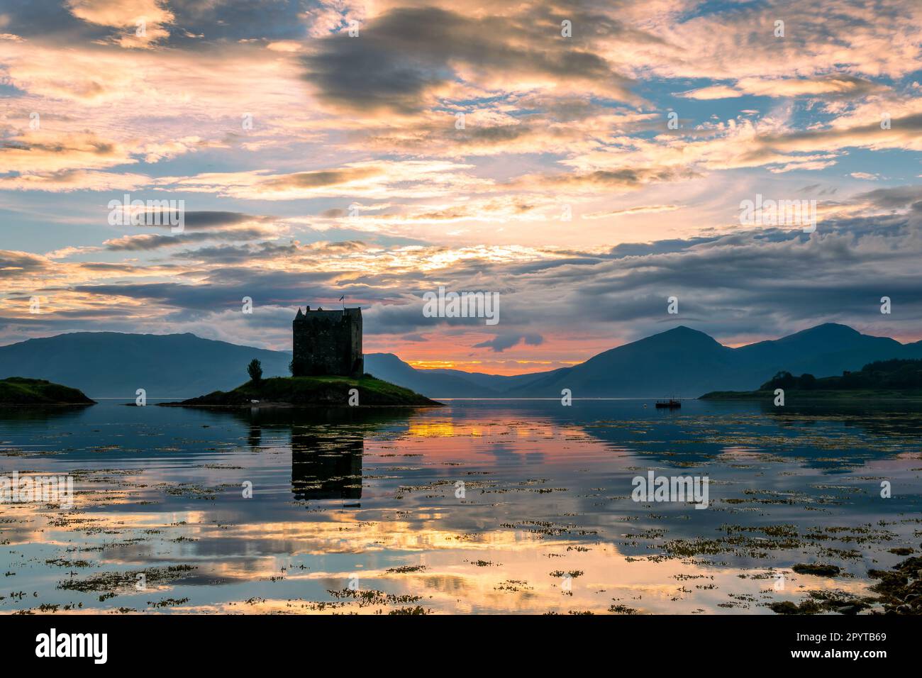 Castle Stalker on Loch Laich with water reflections at sunset, Argyll, Scotland UK Stock Photo