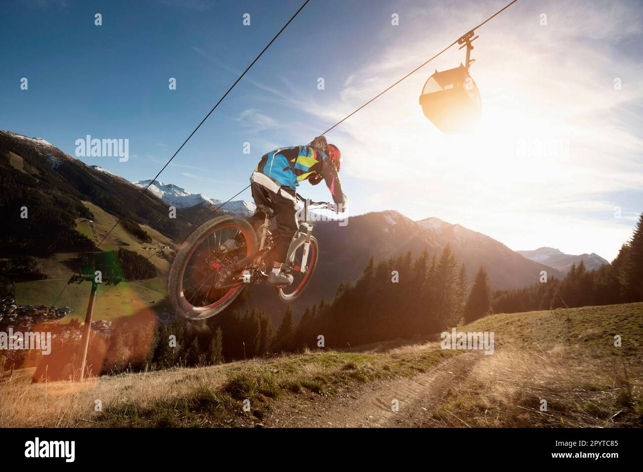 Rear view of a mountain biker jumps over a bump, Saalbach-Hinterglemm, Zell am See, Salzburg, Austria Stock Photo