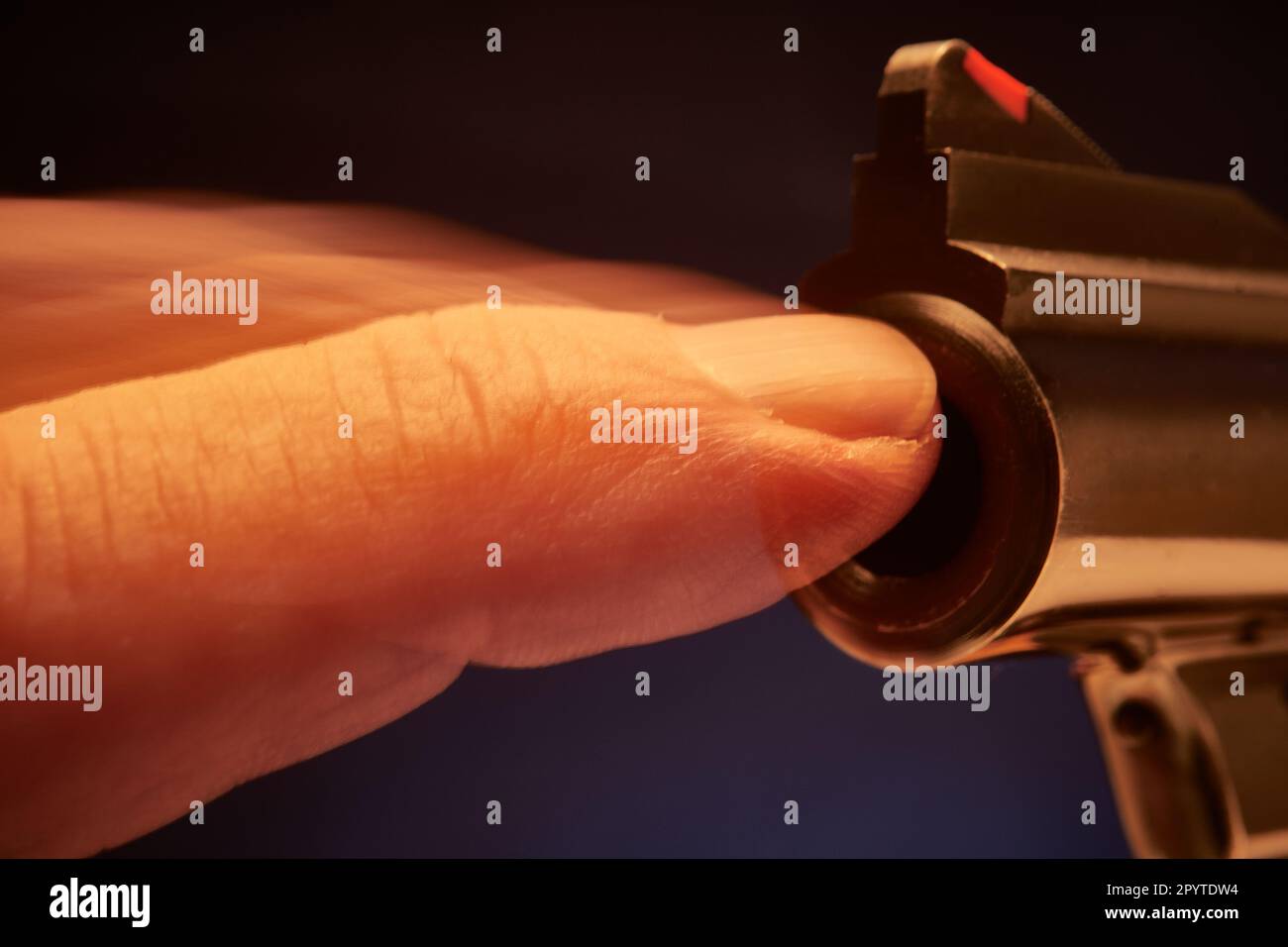 Finger blocking the barrel and the firing of a pistol Stock Photo