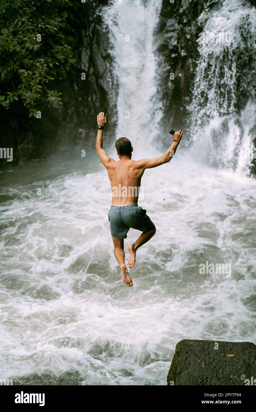 Man jumps from a waterfall. Bali. Stock Photo