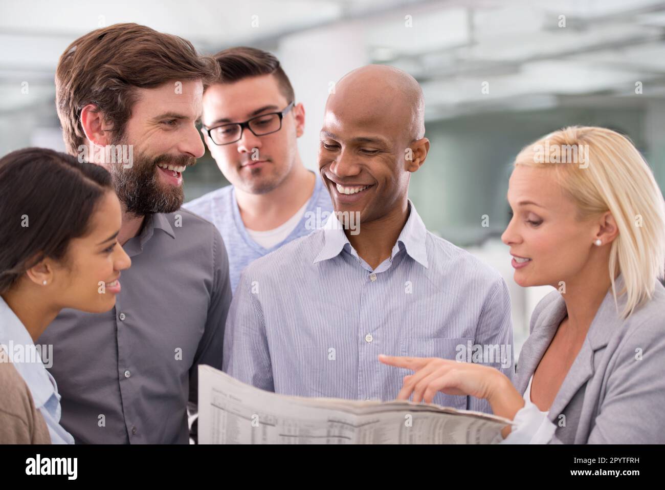 Checking up on the stock figures. a group of work colleagues reading a ...