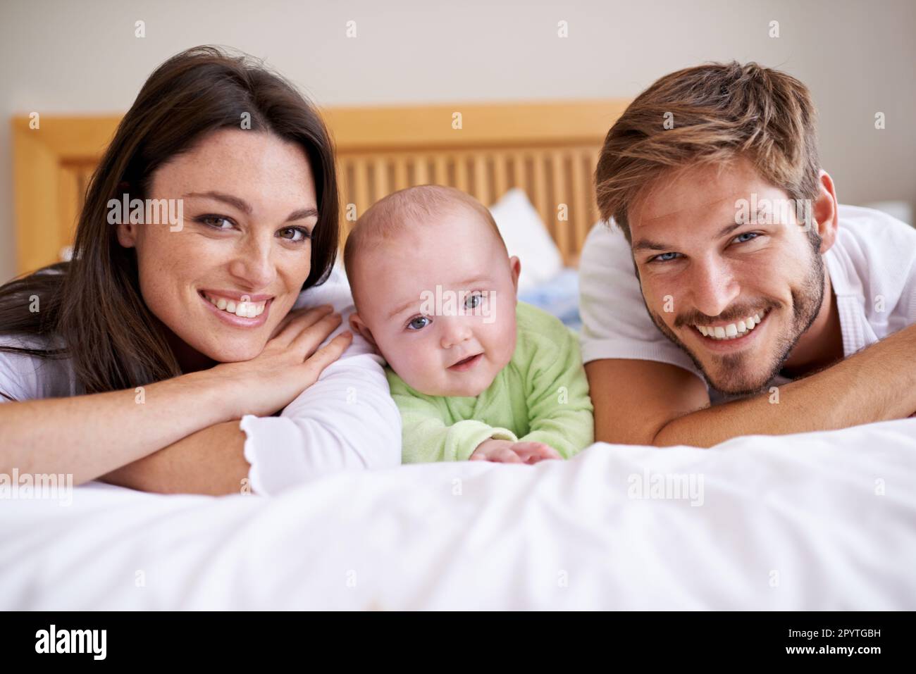 Happy portrait of mother, father and baby on bed for love, care and fun ...