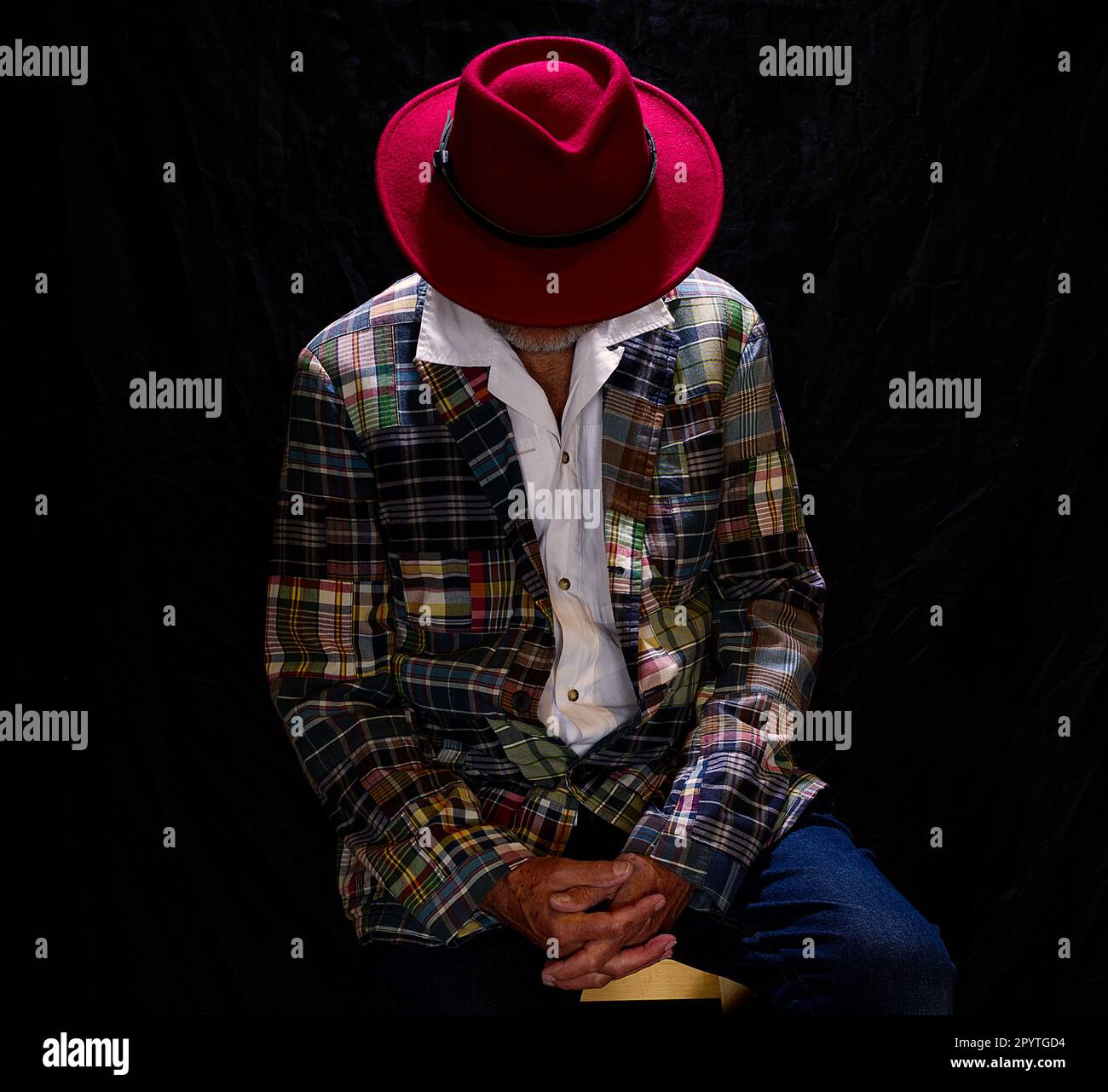 Man with red had handing his face Stock Photo - Alamy