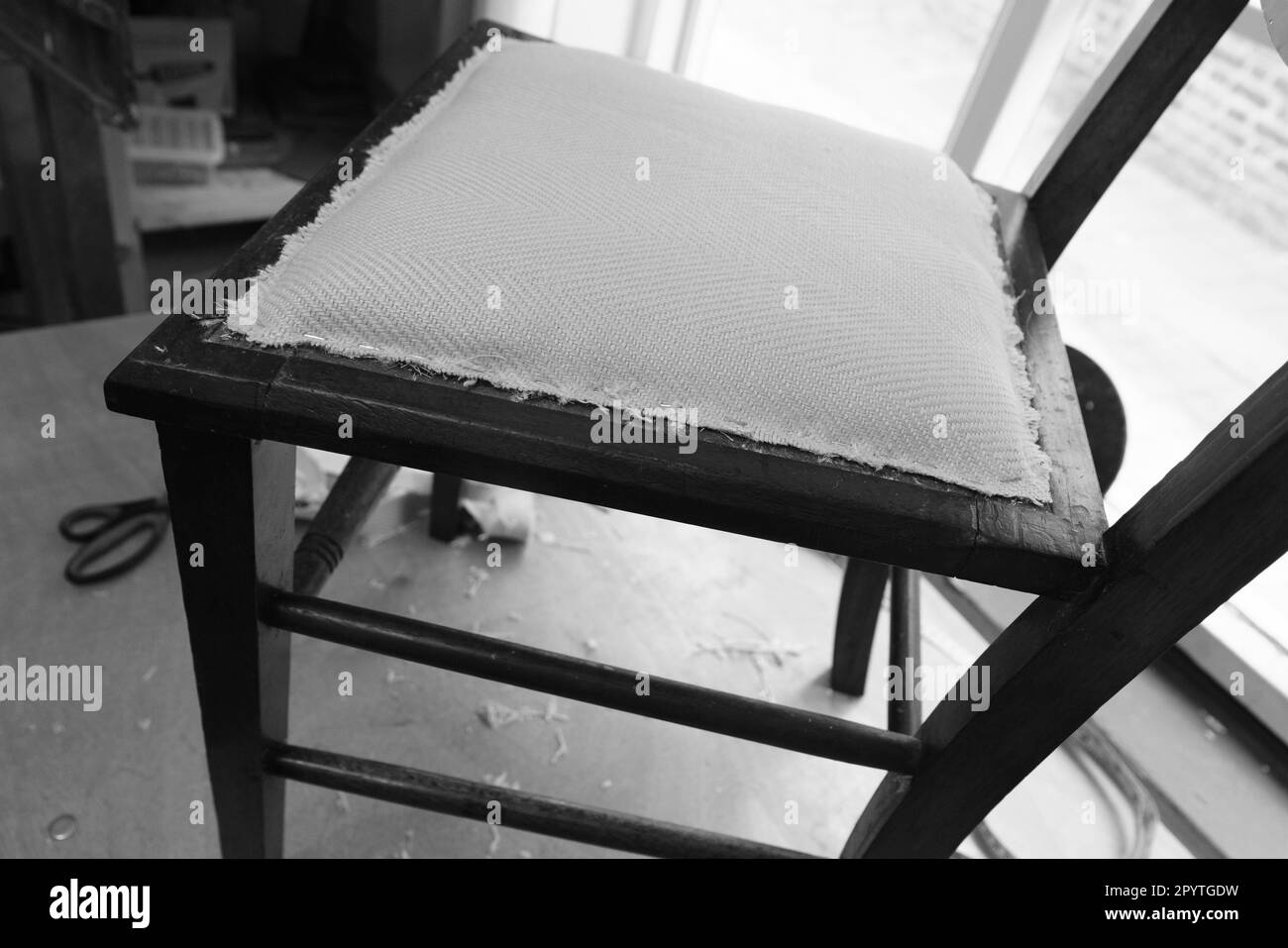 The stages involved in reupholstering a simple dining chair. Black and white images. Stock Photo