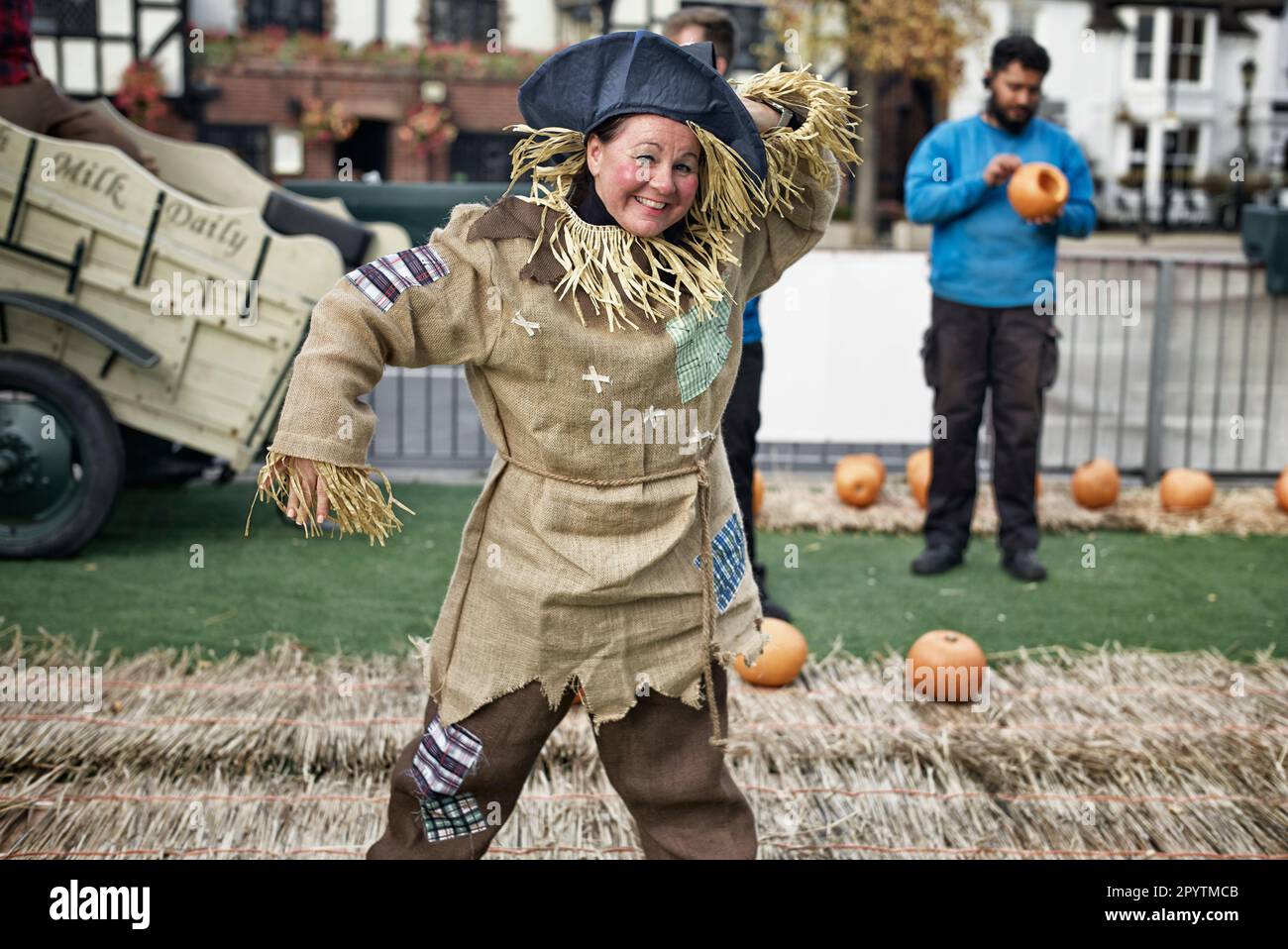 Woman dressed as a straw scarecrow selling pumpkins for the Halloween festivities. England UK Stock Photo