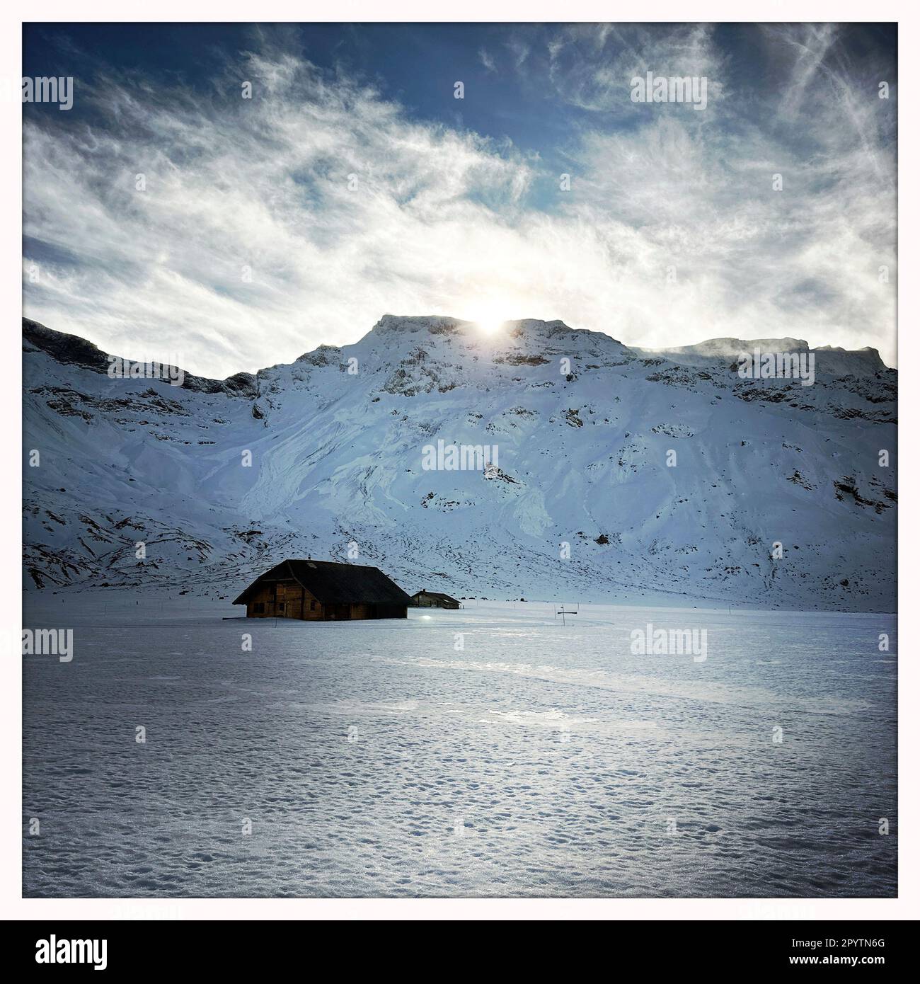 FROM THE SERIES ADELBODEN Mountains in wintry landscape at Engstligenalp in Adelboden, Bernese Oberland, Canton of Bern, Switzerland. The picturesque town of Adelboden is a Swiss idyll in the Bernese Alps, impressive peaks, unique winter landscape, popular ski area, alpine pastures, rushing waterfalls, cozy wooden houses. Due to climate change and less and less snow, the classic winter sports resort is reorienting itself, and the summer season is becoming more important. Photo taken with iPhone, Hipstamatic app. Stock Photo