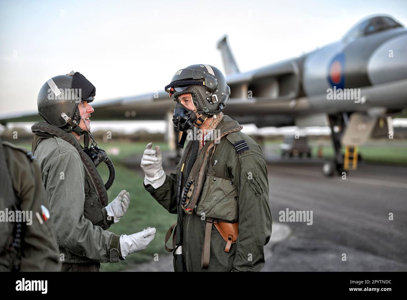 Fighter pilots combat pressure flight suit and oxygen breathing apparatus with the Vulcan Bomber XM 655 aircraft at Wellesbourne Airfield, England UK Stock Photo