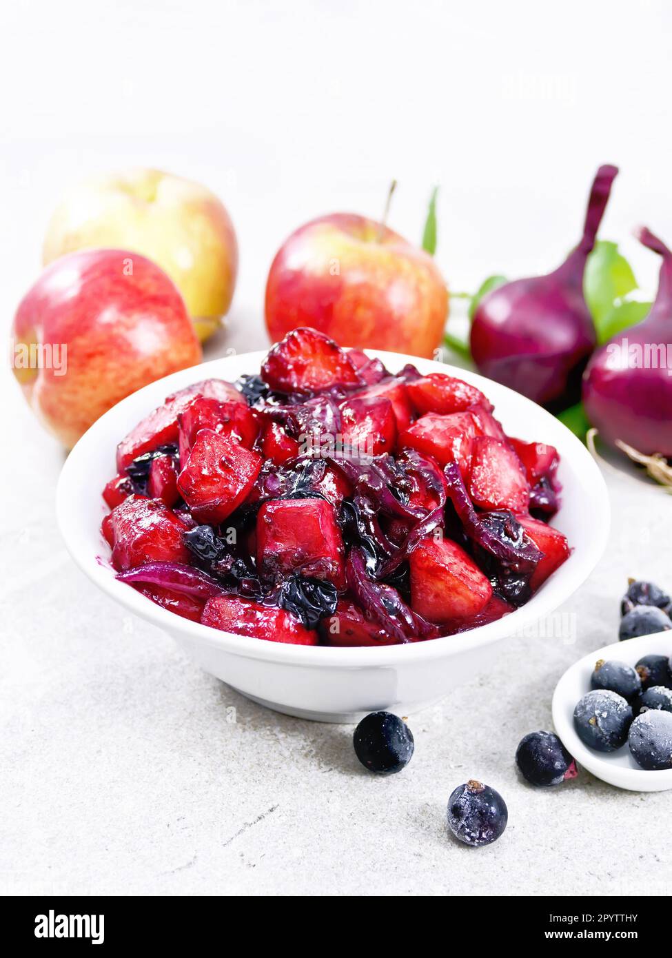 Chutney of apple, red onion and blackcurrant in a bowl against a granit table Stock Photo