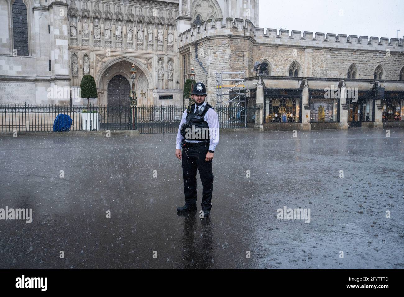 London UK. 5 May 2023. A police officer outise Westminster Abbey is  caught in a heavy downpour  a day before the coronation of King Charles III,  the biggest ceremonial event staged in the capital for 70 years. Credit: amer ghazzal/Alamy Live News Stock Photo