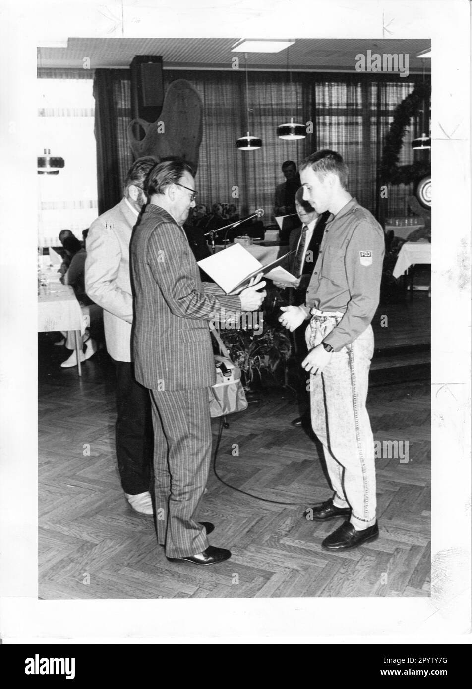 Prof. Dr. Kuhn, Deputy State Secretary for Vocational Training, honors Thomas Brückner for his outstanding performance in the international bricklaying competition in Potsdam. Competition. Performance comparison. Award. GDR. Historic. Turn. Apprentice. Bricklayer. Turning point. Photo. Joachim Liebe, 22.06.1989 [automated translation] Stock Photo