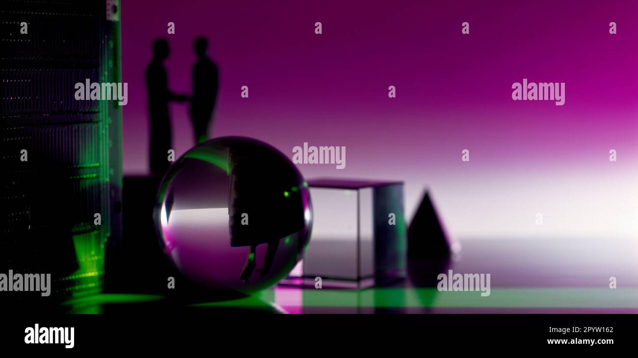 Concept. Business / Science. Still life geometric glass objects & silhouette of two men shaking hands. Stock Photo
