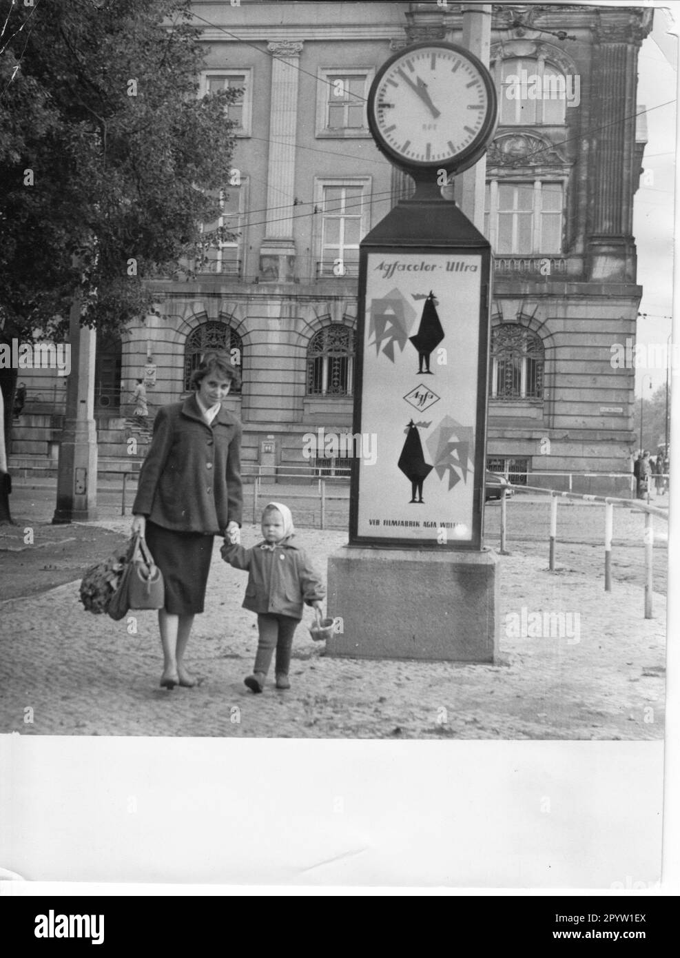 Mother with child and full shopping bags. Next to it the grandfather clock standing on Friedrich- Ebert-Straße in front of the Old Town Hall in Potsdam.GDR. Photo: MAZ/Leon Schmidtke, September 1960 [automated translation] Stock Photo