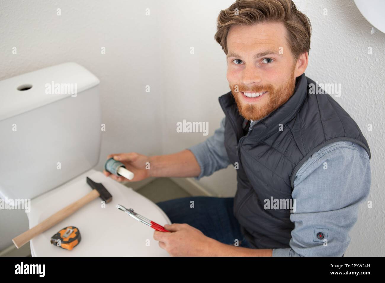 plumber repairing toilet cistern at water closet Stock Photo Alamy