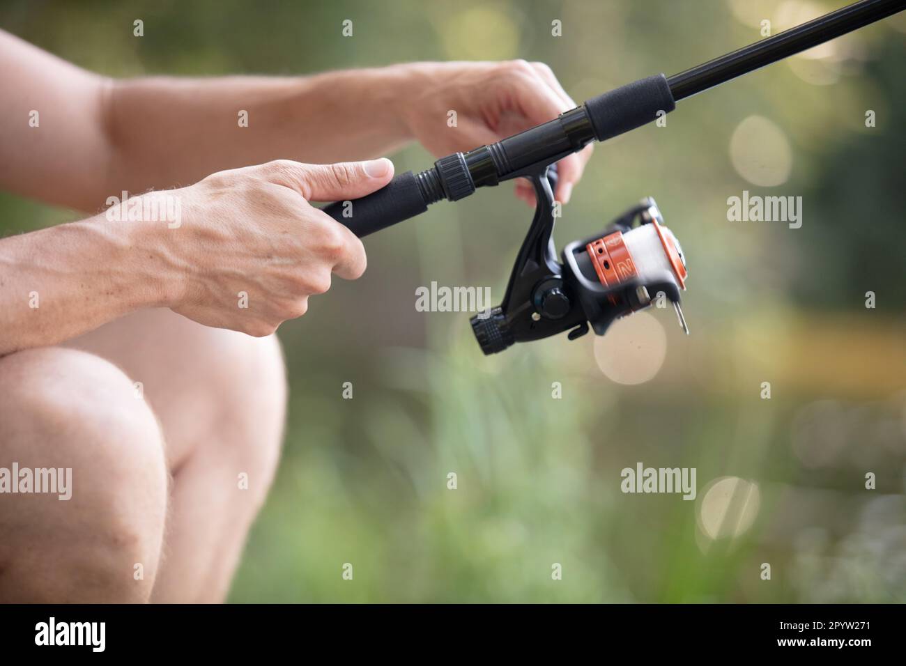 human hand holding fishing rod Stock Photo - Alamy