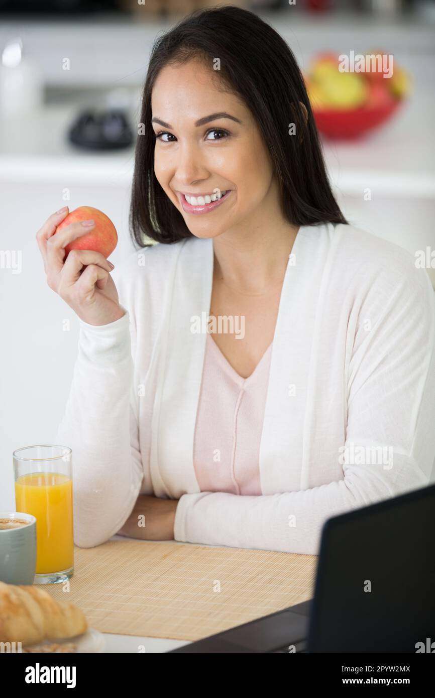 healthy woman eating an apple for breakfast Stock Photo Alamy