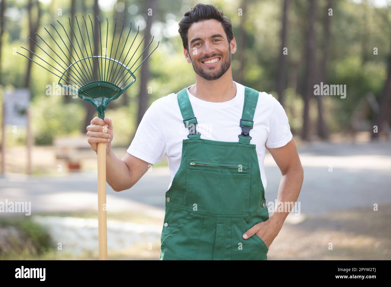 portrait of a male gardener holding a rake Stock Photo - Alamy