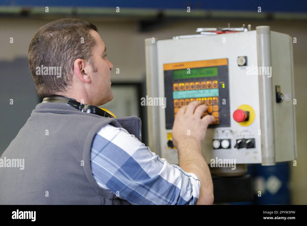 factory worker operating machine units in workshop Stock Photo